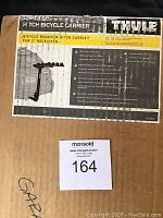 Photo of the original box showing Thule branding and model information. Box labeled as a hitch bicycle carrier for 2-inch receivers.