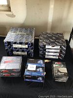 Photo of brake rotors and multiple brake pad boxes arranged on a black surface, showing labels and packaging for Centric and PBR branded products.