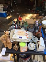 Lot displayed on table including ceramic figurines, boxed picture frames, tea cups, glassware and decorative items