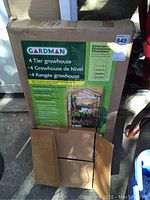 Box of Gardman 4 tier greenhouse with brand and product specifications including dimensions 27x19x63 inches.