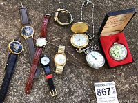 Lot of nine watches and pocket watches including a gold-tone Majestime pocket watch in original box, multiple wristwatches with leather, metal, and fabric bands laid out on surface
