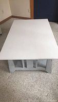 Top view of white rectangular coffee table with smooth surface and lower shelf