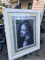 Framed portrait print of a woman with curly hair, shown from the front.