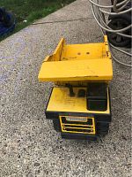 Yellow Tonka metal kid's dump truck toy visible from front, showing grille and cab with green tinted windows.