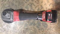 Top view of Milwaukee M18 FUEL cordless angle grinder, showing red and black body and battery.