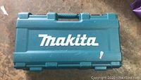 Closed blue plastic carrying case with large white Makita logo on the top surface.