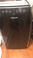 Front view of black Honeywell portable air conditioner showing brand logo and control buttons.