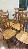 Group photo of six wooden dining chairs showing backs and seats