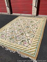 Full view of the large hand knotted Turkish rug with floral pattern and bordered edge.