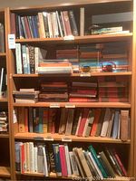 Front view of wooden bookcase filled with books (not included) showing overall condition and size.