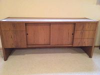 Full view of the wooden credenza showing its mid-century modern style with sliding doors and drawers.