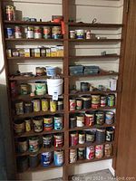 Shelves filled with repurposed cans and boxes each containing different sizes and types of nails, screws, and hardware items