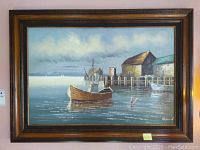 Full view of the framed harbor painting showing boats, dock buildings, sky, and water reflections
