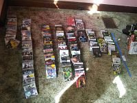 Wide view of dozens of disc-based video games fanned out on carpet