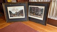 Two framed prints leaning against wooden paneling, showing overall size, frames, and art details.