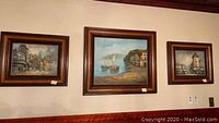 Group shot of three framed paintings hung on wall