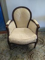 Front view of the chair showing wood frame, fabric upholstery, and seat cushion.