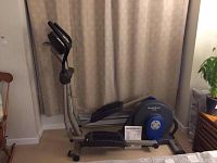 Side view of elliptical showing frame, pedals, console and included manual