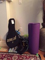Full lot view showing black Prince tennis racket case with 'Prince' logo, purple yoga mat, parts of hand weights and fitness bands in background