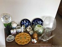 Lot with wall clock, two decorative floral plates, antique dishes, heavy iron, metal birds, glass vase, and ceramic items