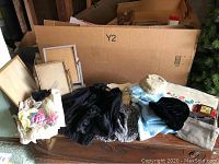 Overview of the lot showing sweater, purses, picture frames, and accessories placed on a wooden surface.
