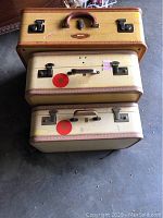 Top view of three stacked yellow suitcases showing handles, locks, and logos.