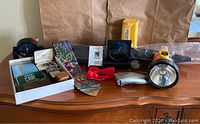 Full lot overview of men's accessories on dresser including wallets, clocks, ties, flashlight, and umbrella