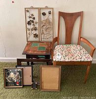 Full lot setup showing wood chair with floral seat, small accent table with tiles, two metal floral decor pieces on wall, and empty frames arranged in front