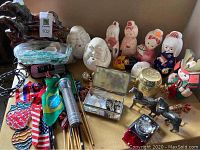 Overview of all items showing Asian dolls and figurines, ceramic horse lamp, flags, and other small items spread out on a surface