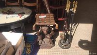 Photo of metal monkey end table with padded top and full fireplace tool set with stand