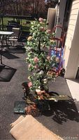 Full view of the vintage jade Chinese flower tree with pink flowers and detachable base outdoors.