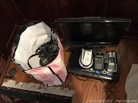 TV, DVD player, CD player, calculators and bag of cables placed on floor.