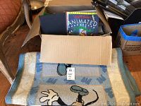 Box of Disney books with visible titles and a large black book on top