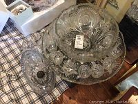 Punch bowl placed on serving tray surrounded by 14 saucers showing overall set layout and design