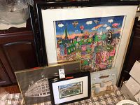 All four art pieces leaning against cabinet and each other