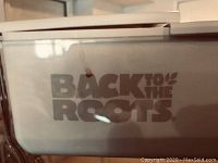 Close-up of the 'Back to the Roots' branded label on the aquarium planter