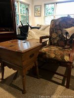 Photo showing floral upholstered side chair next to two wooden doughboy end tables with one table's top closed.