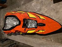 Top view of the orange and yellow inflatable kayak showing its shape and deck area.