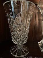 Front view of the clear crystal vase showing intricate diamond and starburst cut patterns and flared rim.