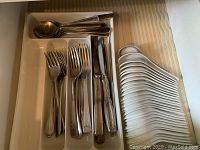 Drawer with organized cutlery: forks, spoons, knives in cutlery tray