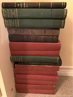 Stack of 17 hardcover books in assorted cloth bindings (black, green, brown, red, blue).