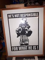 Framed black and white art print with text 'HE'S NOT RESPONSIBLE FOR WHAT HE IS!'