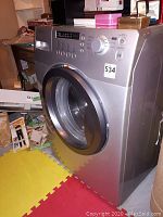 Silver Samsung front load washing machine with control panel and door visible.