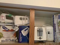 Photo showing Cuisinart white 7-speed hand blender with cords and attachments, Kenwood hand blender box, white Aroma rice cooker, Danescook kitchen scale box, and 7-piece cookie press set box.