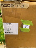 Close-up image of the cardboard box with Moderna branding and product label showing dimensions and weight.