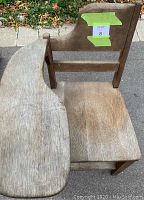 Side and top view of the antique wooden school chair showing the curved desk attached to the right side and the wooden seat with storage space underneath.