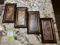Four framed animal art prints laid out on a table: giraffe, tiger, leopard, and elephants.