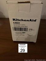 Photo of the sealed white box packaging of KitchenAid K45DH Dough Hook coated attachment, showing the product label and model compatibility.