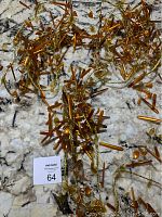 Three pieces of gold and brown Christmas garland arranged on a granite surface, showing tangled metallic and translucent decorations.