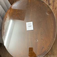 Top view of oval glass top showing scratches and wear marks.